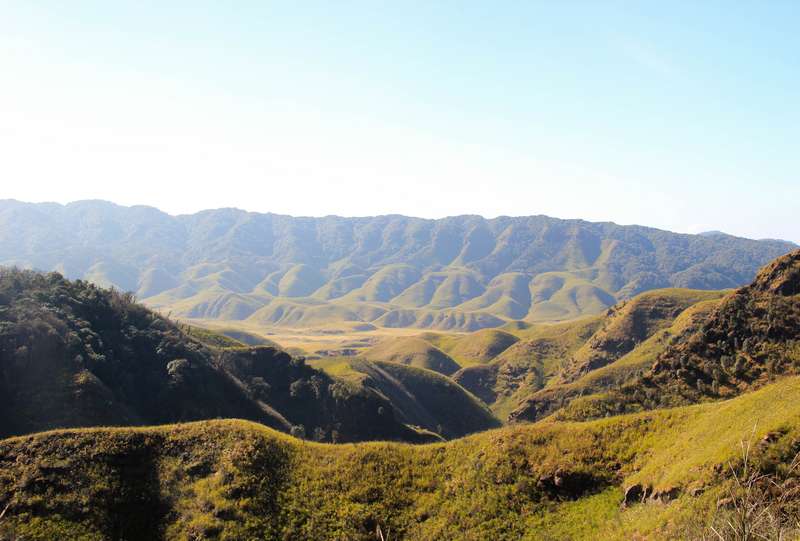 Wide grassland-and-hill panorama, representative of the Kaziranga floodplain